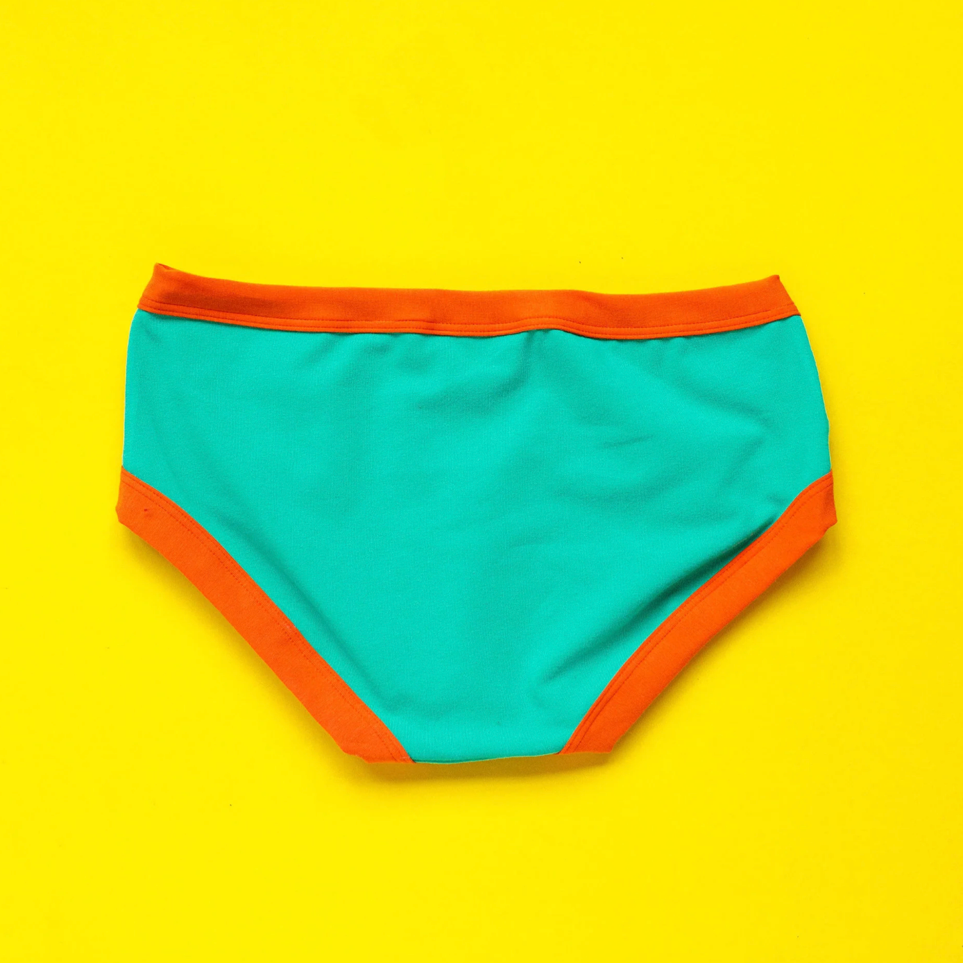 Turquoise and orange women's underwear on a yellow background