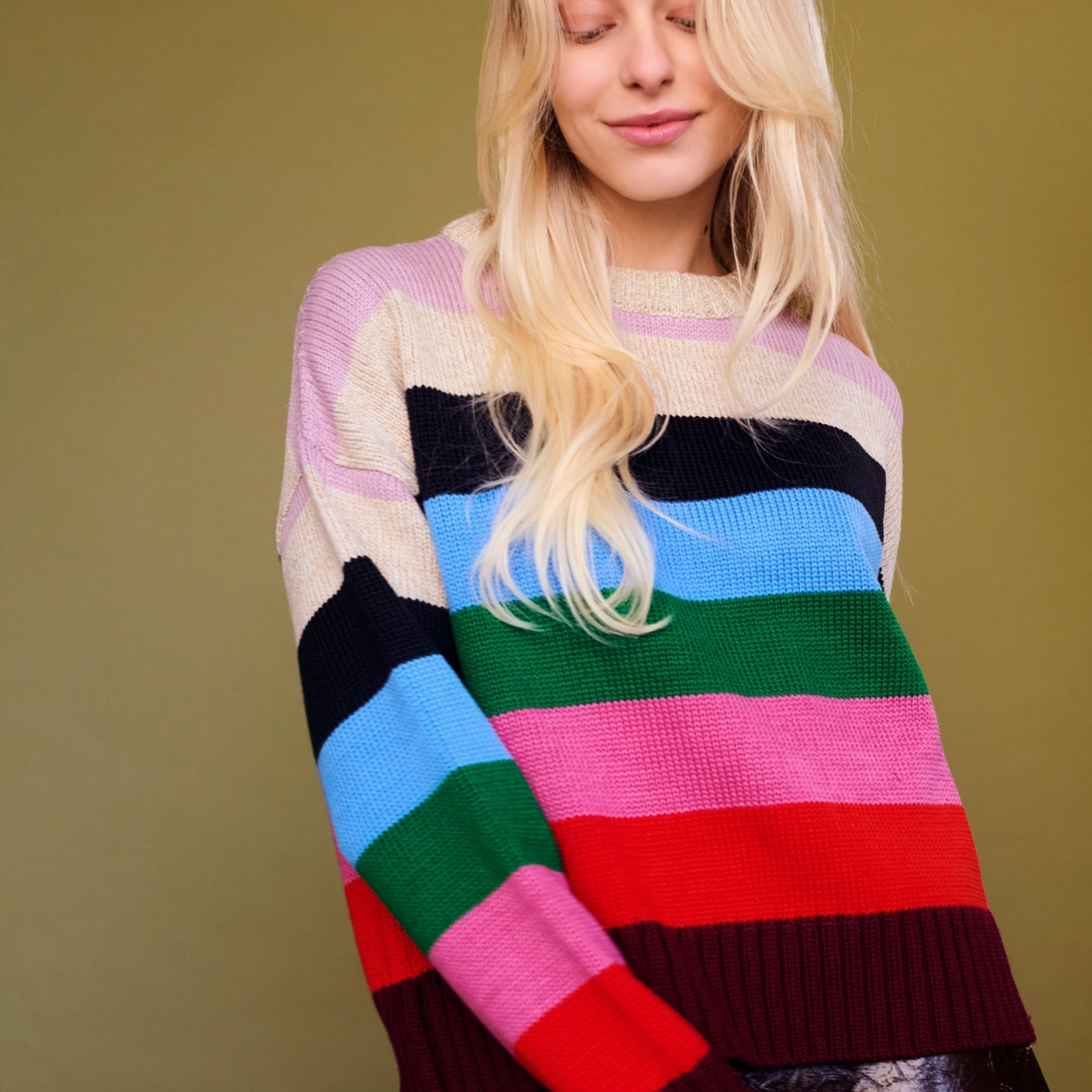 Person wearing a colorful striped sweater against a plain background