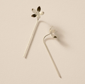 Silver earrings with floral designs on a beige background