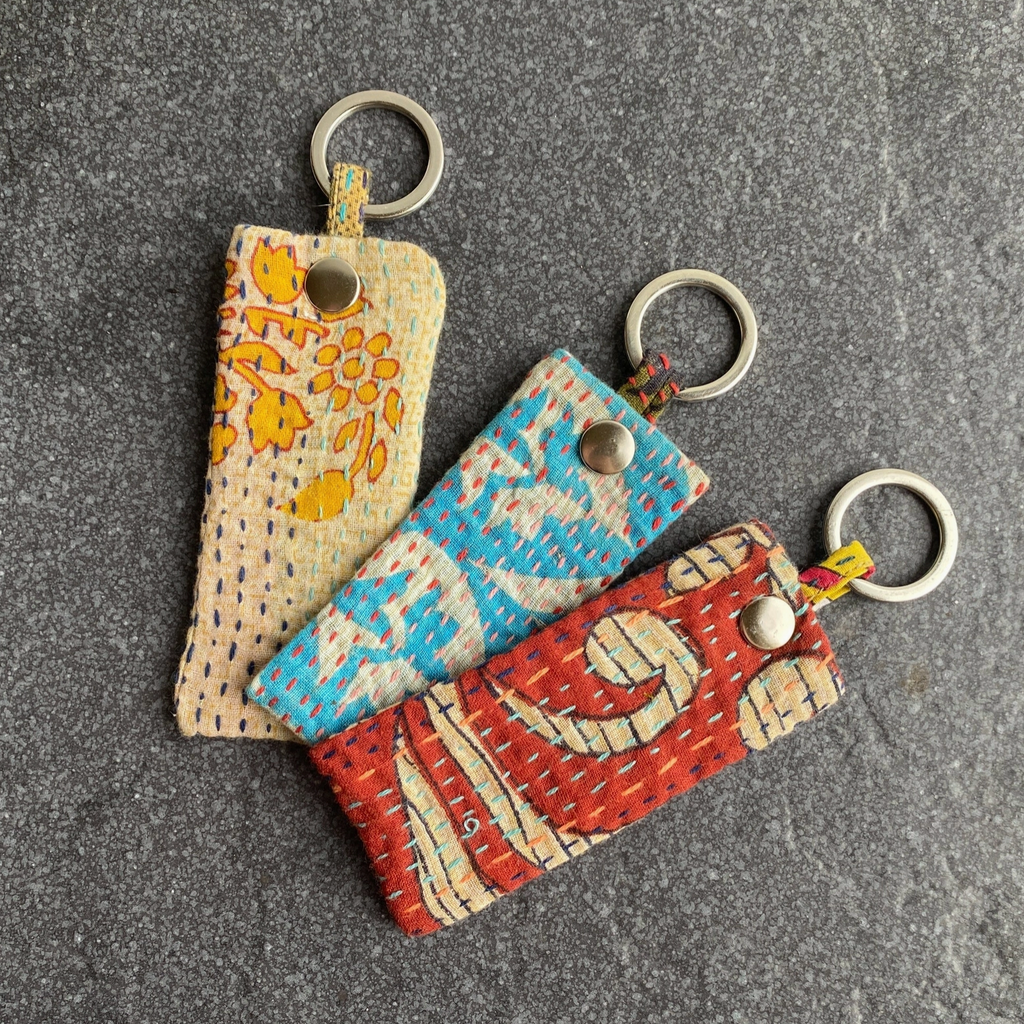Three fabric keychains with different patterns on a gray surface