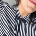 Close-up of a person wearing a black and white striped shirt with a bow tie.